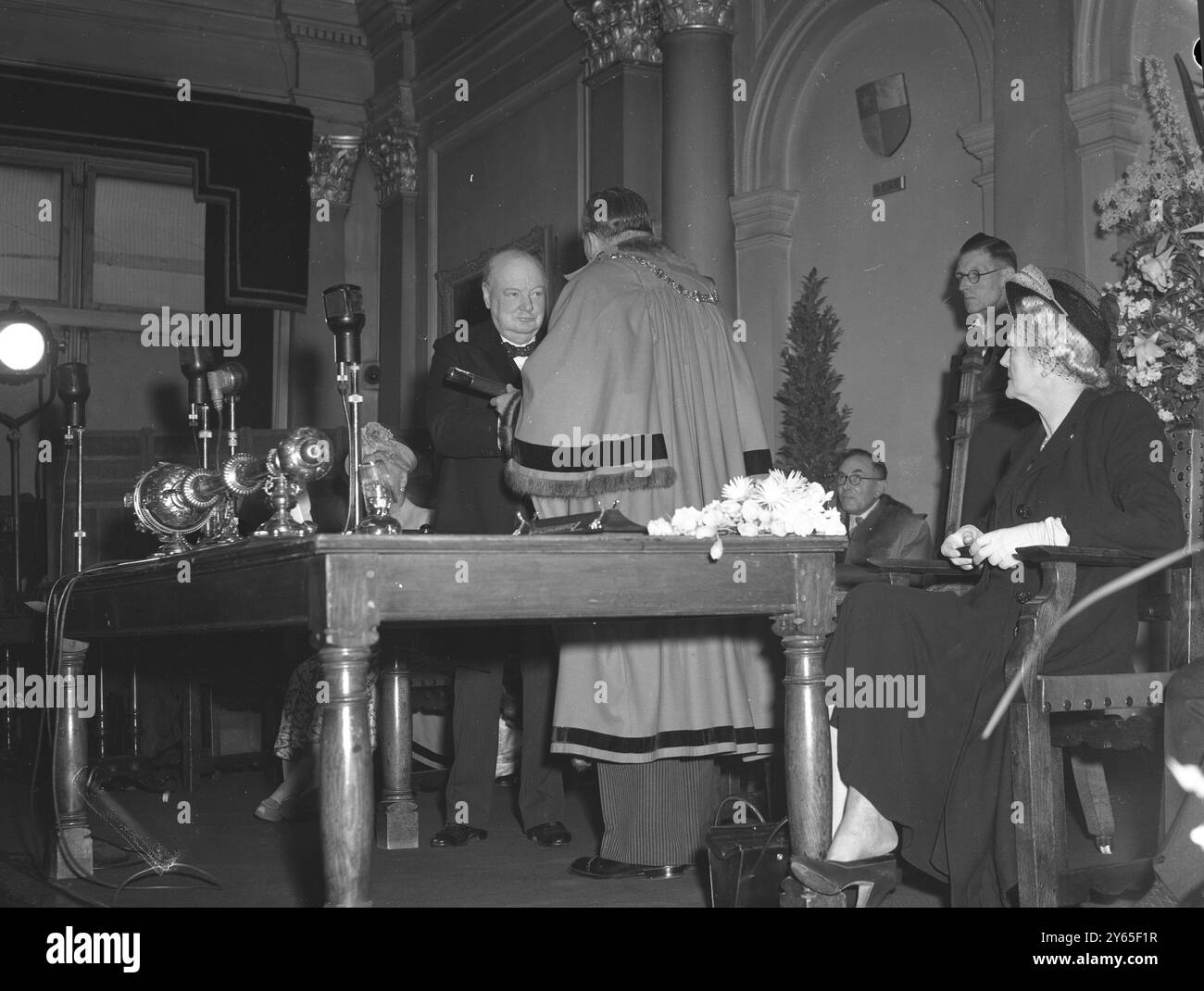 M. Churchill devient Un homme libre du Royal Borough à la mairie de Kensington , le RT Hon Winston Churchill a reçu le rouleau de la liberté du Royal Borogh de Kensington , par son culte le maire , conseiller J , H Huxley , DFC , JP le maire de Kensington présente le bâton contenant le rouleau de la liberté du Borough à M. Churchill à la mairie , surveillé par Mme Churchill à droite le 1er juin 1949 Banque D'Images