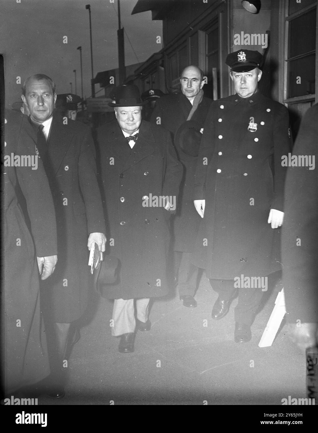 Arrivée à Idlewild le premier ministre britannique Sir Winston Churchill est arrivé à l'aéroport international d'Idlewild à 7 . 20 HEURES en route à la maison de deux semaines de vacances en Jamaïque . L'homme d'État de 78 ans a volé de Montego Bay , Jamaïque , à bord d'une constellation British Overseas Airways Corp , après un retard de 10 heures dans son départ pour l'échouement mondial des Stratocruisers britanniques pour des enquêtes sur les défauts de moteur signalés. Churchill quitta immédiatement l'aéroport en limousine pour embarquer sur le paquebot britannique Queen Mary , qui devait partir pour l'Angleterre. Il était accompagné de Mme Churchil Banque D'Images