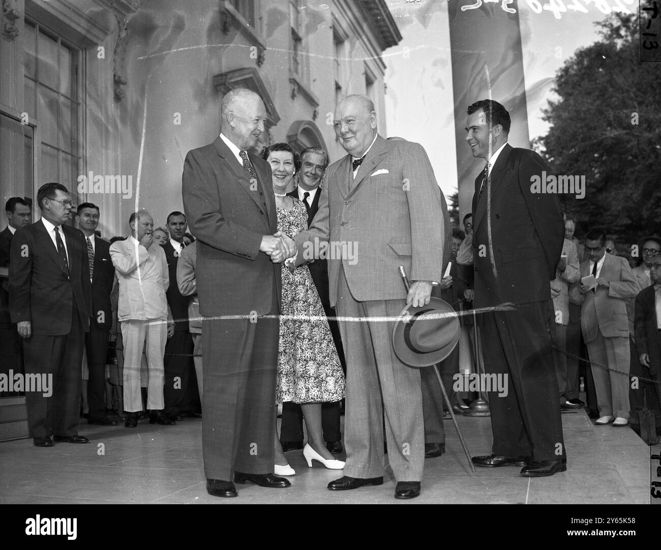 Le premier ministre britannique , Sir Winston Churchill serre la main du président américain , Dwight d Eisenhower, surveillé par une première dame souriante , Mamie Eisenhower , derrière Sir Anthony Eden et le vice-président , Richard Nixon à l'extrême gauche . Sir Winston et Sir Anthony Eden sont en visite à Washington. 1954 Banque D'Images