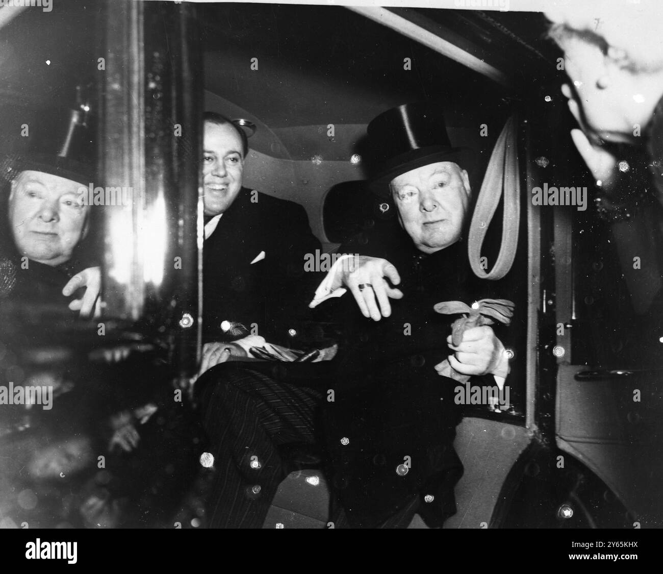 Wifely Touch Lady Churchill ( à droite ) souffle un baiser à son mari , le premier ministre , Sir Winston Churchill , alors qu'il quitte le .10 Downing Street pour l'ouverture du Parlement par l'État . A côté de Sir Winston se trouve le capitaine Christopher Soames , son beau-fils . 30 novembre 1954 Banque D'Images