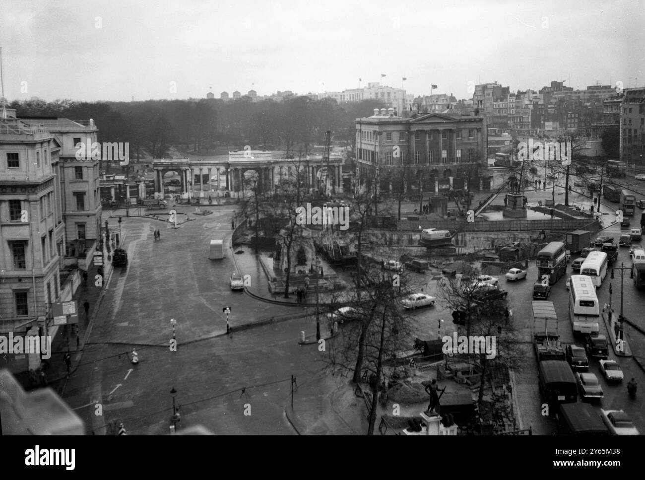 Trafic londonien négociation de la route autour de Hyde Park Corner . L'écran Hyde Park Corner et Apsley House peuvent être vus à l'arrière. Grues et travaux de construction peuvent être vus comme la construction du nouveau passage inférieur a commencé . Il s'agissait d'une section des améliorations de la route Marble Arch - Park Lane - Hyde Park Corner. Cela faisait partie d'un plan pour soulager la congestion du trafic sur les routes du centre de Londres. Il a été ouvert en 1962 le 6 février 1961 Banque D'Images