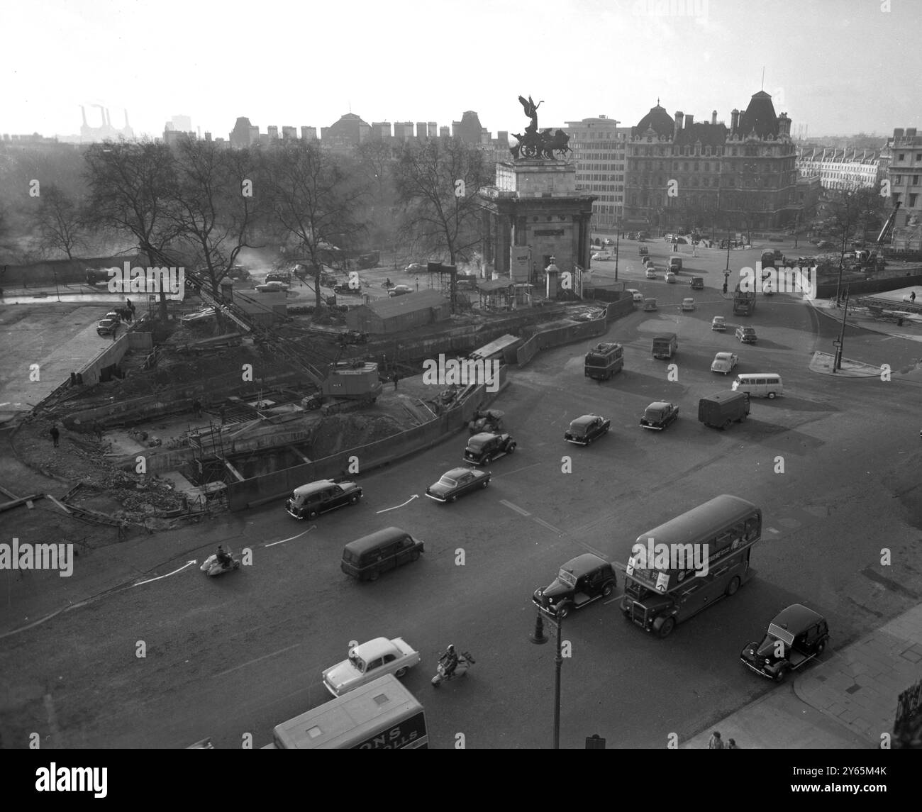 Trafic londonien négociation de la route autour de l'Arche Wellington . Grues et travaux de construction peuvent être vus comme la construction du nouveau passage inférieur a commencé . Il s'agissait d'une section des améliorations de la route Marble Arch - Park Lane - Hyde Park Corner. Cela faisait partie d'un plan pour soulager la congestion du trafic sur les routes du centre de Londres. Il a été ouvert en 1962 le 6 février 1961 Banque D'Images