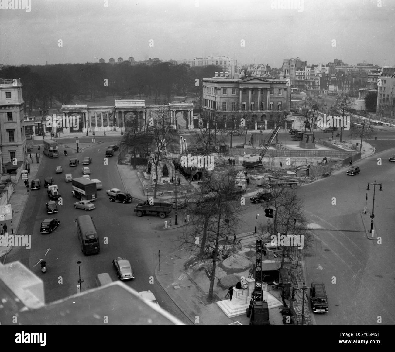 Trafic londonien négociation de la route autour de Hyde Park Corner . L'écran Hyde Park Corner et Apsley House peuvent être vus à l'arrière. Grues et travaux de construction peuvent être vus comme la construction du nouveau passage inférieur a commencé . Il s'agissait d'une section des améliorations de la route Marble Arch - Park Lane - Hyde Park Corner. Cela faisait partie d'un plan pour soulager la congestion du trafic sur les routes du centre de Londres. Il a été ouvert en 1962 le 6 février 1961 Banque D'Images