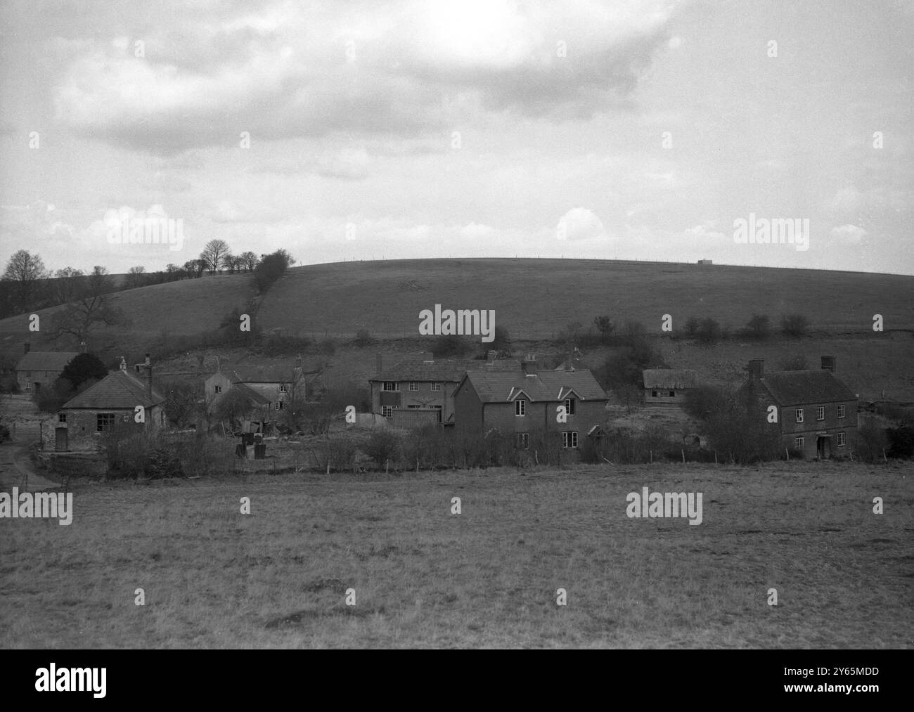 Les villageois d’Imber attendent depuis 1943 la permission de rentrer chez eux, mais ils savent maintenant que leur magnifique Domesday Village restera à jamais déserté au centre d’une école de combat militaire. La photo montre une partie du village d'Imber vue de la montée du sol qui surplombe la vallée dans laquelle il se niche. Des fenêtres sans verre, des jardins envahis par la végétation et un manque d'activité humaine constituent la scène de la désolation silencieuse du 6 avril 1948 Banque D'Images