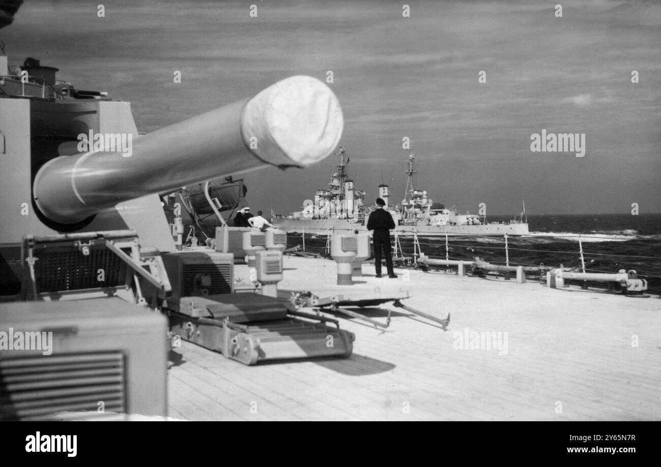 La Grande-Bretagne exerce sa puissance en mer dans les plus grandes manœuvres depuis 1939 - opération Dawn le croiseur 'Superb' - navire amiral de l'opération Dawn vu passer à grande vitesse sous les gros canons du HMS Anson . Banque D'Images