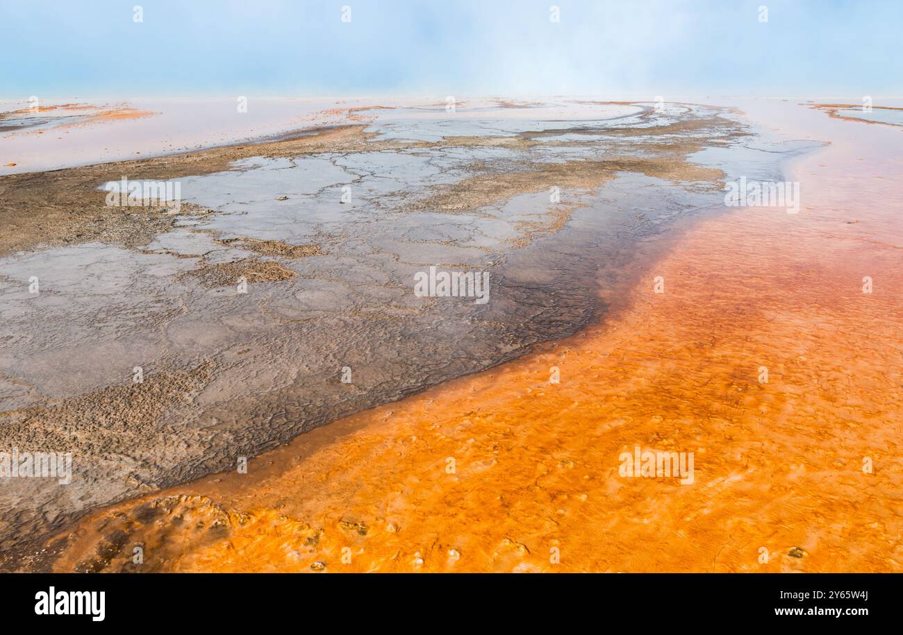 Un paysage saisissant mettant en valeur les zones de ruissellement de sources chaudes vibrantes et riches en minéraux du parc national de Yellowstone, caractérisées par des oranges chaudes et muets Banque D'Images