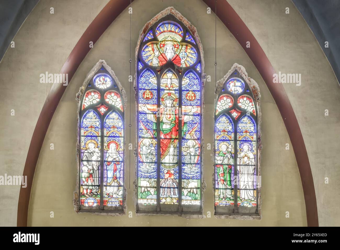 Une paire exquise de vitraux représentant des personnages religieux illuminés dans un cadre d'église. Banque D'Images