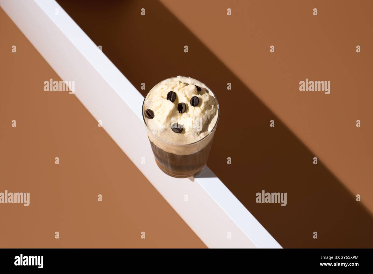 Vue de dessus de délicieux affogato avec expresso riche garni de crème glacée à la vanille crémeuse et grains de café, stylisé sur un fond beige minimaliste. Banque D'Images