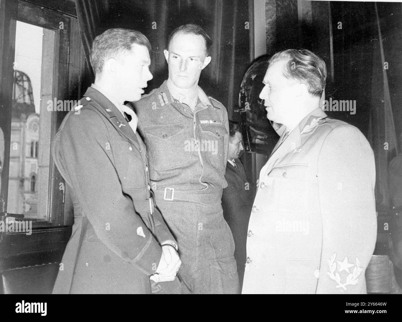 La prestation de serment du gouvernement yougoslave, le colonel Thayer, à gauche, chef de la mission américaine, et le brigadier MacLean, chef de la mission britannique, sont photographiés en train de discuter avec le maréchal Tito. Mars 1945 Banque D'Images