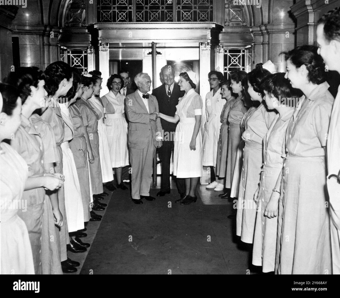 Sir Alexander Fleming Vistis New York Hospital. Devant deux rangées d’infirmières, Sir Alexander Fleming est accueilli par Annette Schneider, étudiante infirmière, tandis qu’au centre se trouve Mme Charles Silver, présidente de l’Hôpital. 15 juillet 1949 Fleming, Alexander, Sir Scottish bactériologiste ; découverte de la pénicilline en 1928 ; Prix Nobel de médecine en 1945  1881-1955 Banque D'Images