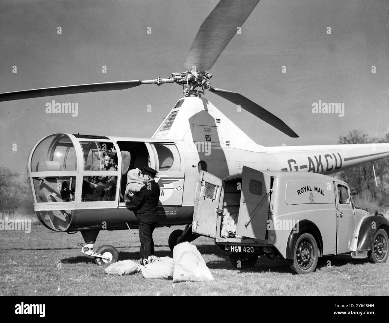 Poste aérien avec une différenceExperiments pour perfectionner un système dans lequel des hélicoptères sont employés pour ramasser et livrer le courrier selon un horaire précis en des points isolés à travers le pays ont été menés aux travaux de la Westland Aircraft Company à Yeovil, Somerset. Le régime est une collaboration entre British European Airways et le GPO , et les hélicoptères Westland-Sikorsky et Irvin-Bell sont les machines employées . L'unité expérimentale de courrier aérien est contrôlée par le commandant d'escadre R A C Brie . Photos : Postman Morris England de Yeovil GPO chargement de sacs postaux dans un hélicoptère Westland-Sikorsky Banque D'Images Poste aérien avec une différenceExperiments pour perfectionner un système dans lequel des hélicoptères sont employés pour ramasser et livrer le courrier selon un horaire précis en des points isolés à travers le pays ont été menés aux travaux de la Westland Aircraft Company à Yeovil, Somerset. Le régime est une collaboration entre British European Airways et le GPO , et les hélicoptères Westland-Sikorsky et Irvin-Bell sont les machines employées . L'unité expérimentale de courrier aérien est contrôlée par le commandant d'escadre R A C Brie . Photos : Postman Morris England de Yeovil GPO chargement de sacs postaux dans un hélicoptère Westland-Sikorsky Banque D'Images