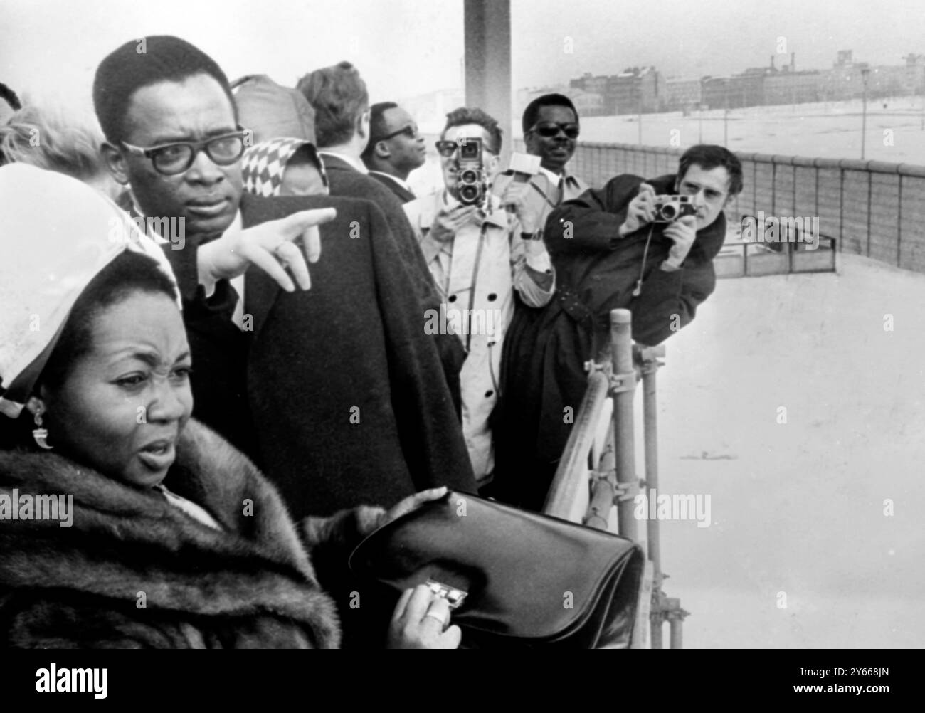 Le président de la République du Congo Joseph Mobutu et son épouse regardant à travers le mur communiste dans le secteur est couvert de neige de Berlin depuis une plate-forme surélevée à Potsdamer Square dans le district de Tiergarten de cette ville divisée le 19 mars 1969 . Le Chef de l'Etat congolais est actuellement en visite d'Etat en Allemagne du .21 au 30 mars 1969 Banque D'Images