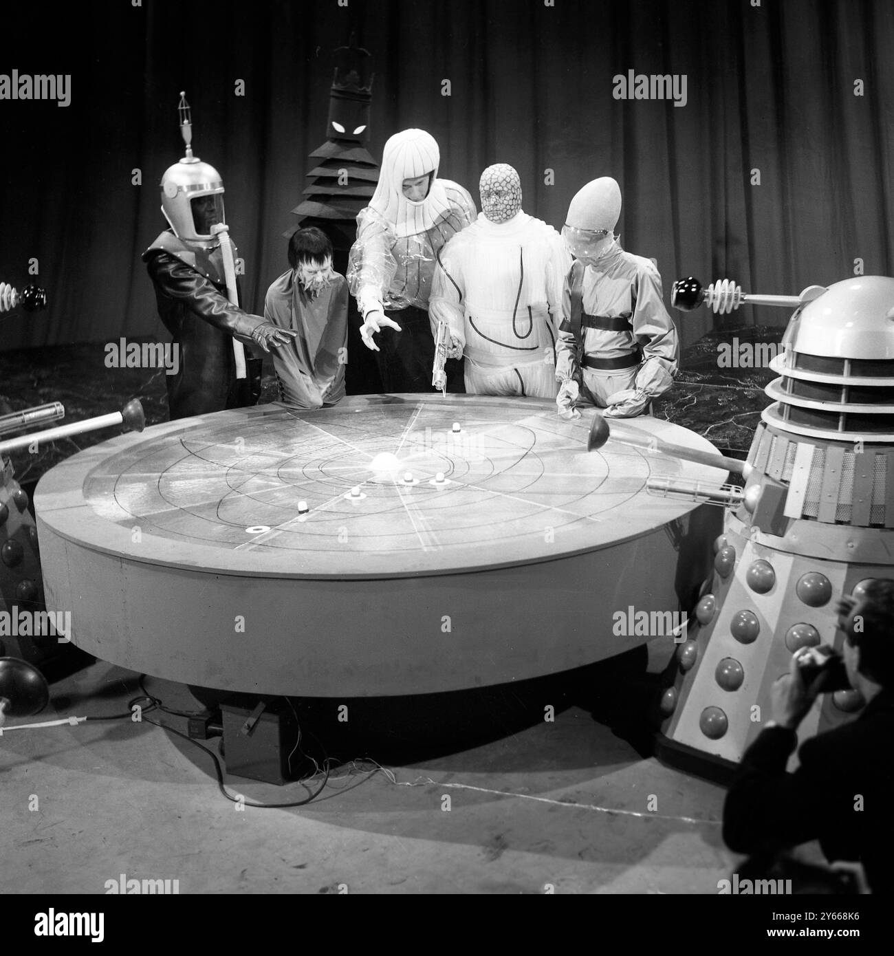 Les bêtes d'Ugh ( quartier général Galactique Uni ) lors d'une réunion secrète d'UGH tenue sur la planète Varga aujourd'hui et convoquée sous le commandement des Daleks , une résolution a été adoptée à l'unanimité par les grandes puissances des galaxies extérieures ( représentants des planètes Gearon , Trantis , Malpha , Sentreal , Beaus et Celation ) que la Terre devrait être totalement détruite. Cette décision mettra en branle plus tard cette année une guerre terrifiante dans laquelle le Dr Who ( William Hartnell ) et ses compagnons Vicki ( Maureen O'Brien ) et Steven ( Peter Purves ) seront dangereusement impliqués. Le Da est également introduit Banque D'Images Les bêtes d'Ugh ( quartier général Galactique Uni ) lors d'une réunion secrète d'UGH tenue sur la planète Varga aujourd'hui et convoquée sous le commandement des Daleks , une résolution a été adoptée à l'unanimité par les grandes puissances des galaxies extérieures ( représentants des planètes Gearon , Trantis , Malpha , Sentreal , Beaus et Celation ) que la Terre devrait être totalement détruite. Cette décision mettra en branle plus tard cette année une guerre terrifiante dans laquelle le Dr Who ( William Hartnell ) et ses compagnons Vicki ( Maureen O'Brien ) et Steven ( Peter Purves ) seront dangereusement impliqués. Le Da est également introduit Banque D'Images