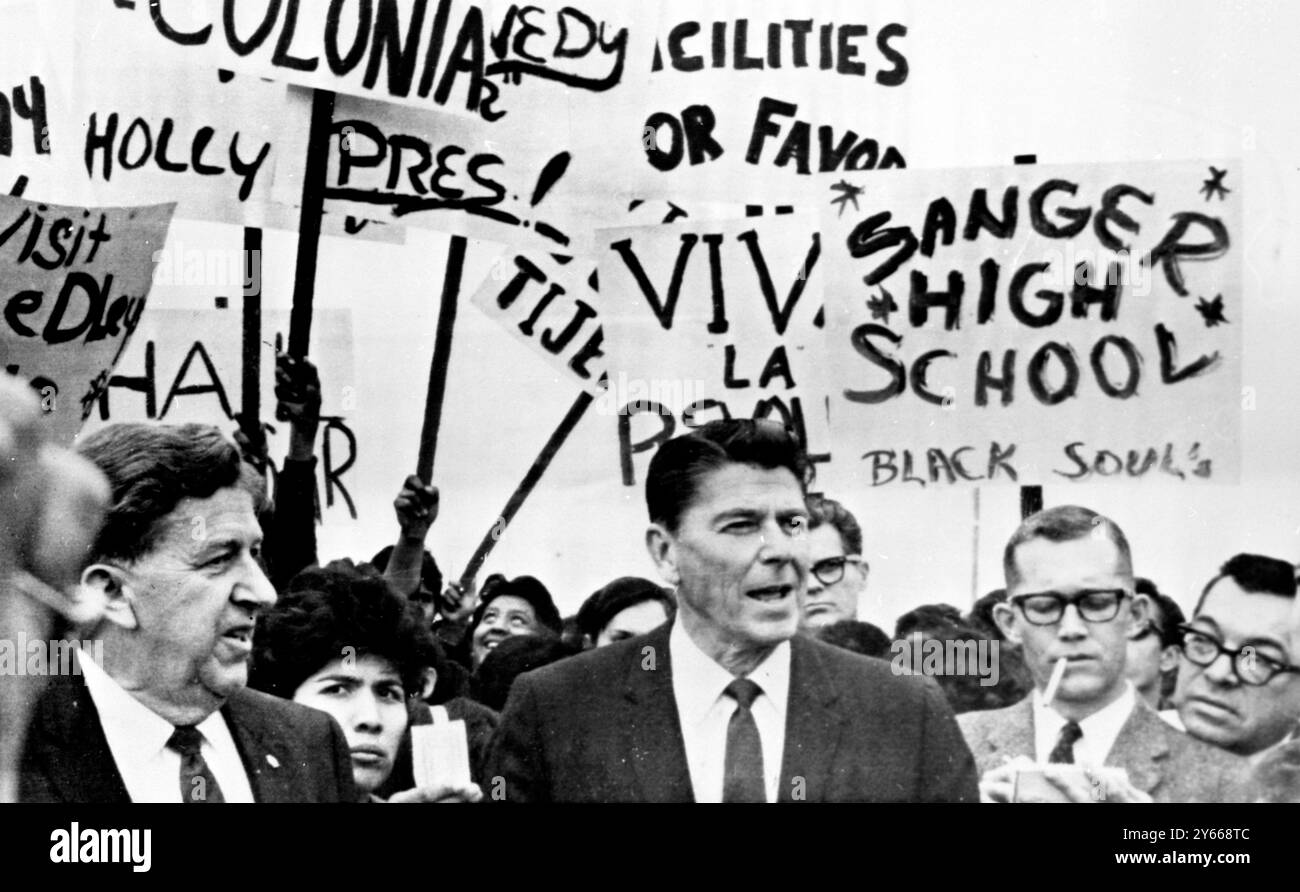 Le gouverneur Ronald Reagan est entouré de journaux et de piquets de grève alors qu'il visitait un centre de logement pour travailleurs migrants dans cette communauté du sud du comté de Fresno 12 mars 1968. Environ 200 personnes l'ont accueilli , principalement des Américains mexicains qui vivent dans la région de la vigne . Beaucoup des 25 piquets de grève , exhortant à tout, de ' retourner à Hollywood ' à ' visiter Reedley ' , étaient des adolescents , Parliament , Californie , États-Unis .15 mars 1968 Banque D'Images