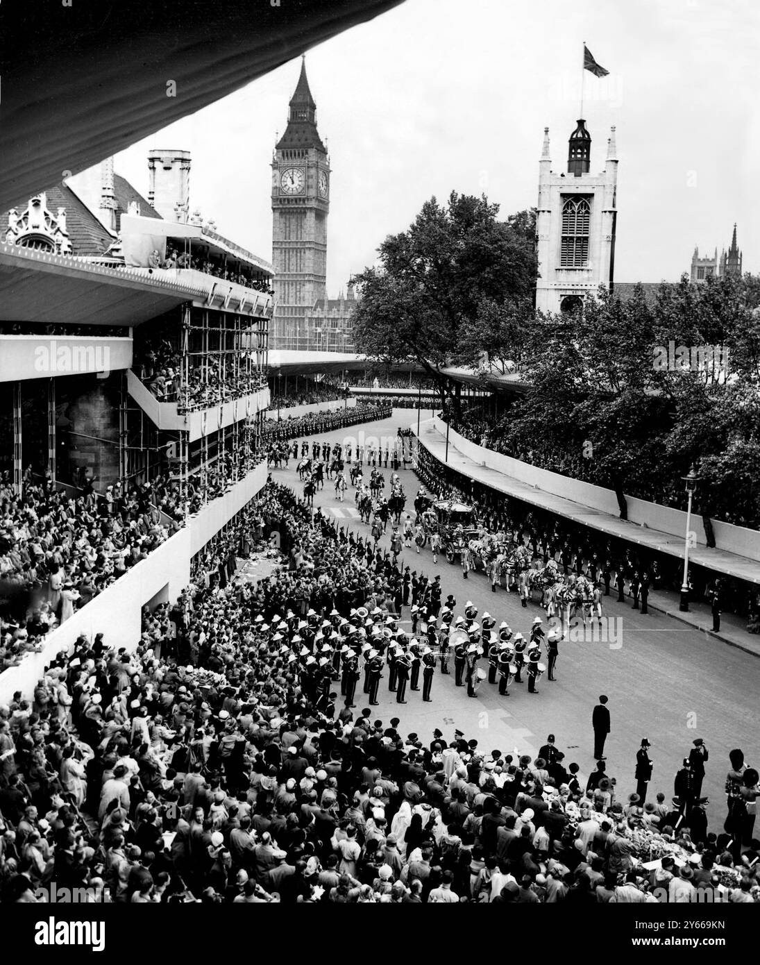 Jour du couronnement - la procession de la reine arrive à l'abbaye de Westminster alors que la reine, à cheval avec l'autocar tiré par huit chevaux gris, arrive à l'abbaye pour son couronnement. Les foules acclamantes emballent les trottoirs et les tribunes et regardant vers le bas sur tout le grand spectacle est la tour de l'horloge Big Ben. 2 juin 1953 Banque D'Images
