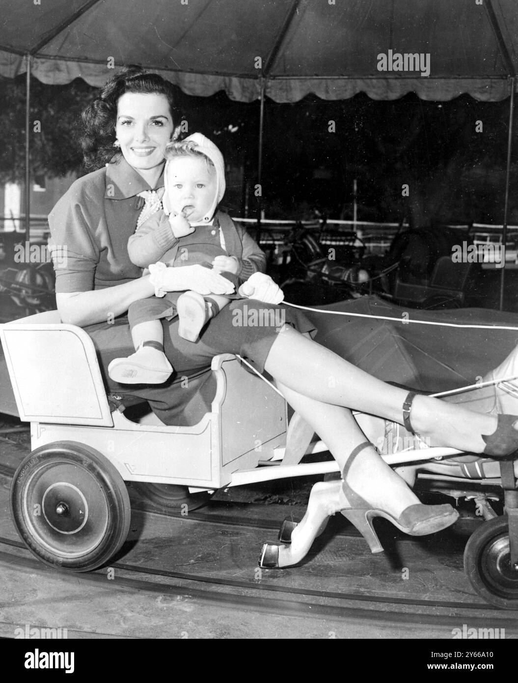 Jane Russell part pour une balade sur le joyeux Go round à Van Nuys California USA avec le Batersea Baby Thomas Kavanagh 17 novembre 1951 Banque D'Images