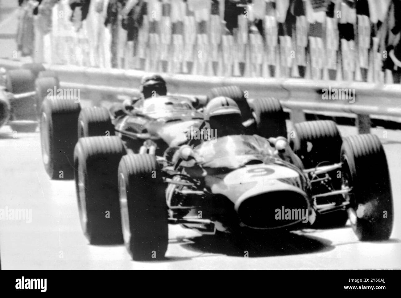 Monaco : le Néo-Zélandais Denis Hulme, au volant d'une Repco-Brabham, mène le peloton sur la ligne d'arrivée du 25e Grand Prix de Monaco. La course a été entachée par le crash de l'as italien Lorenzo Bandini dont la Ferrari s'est renversée. 8 mai 1967 Banque D'Images
