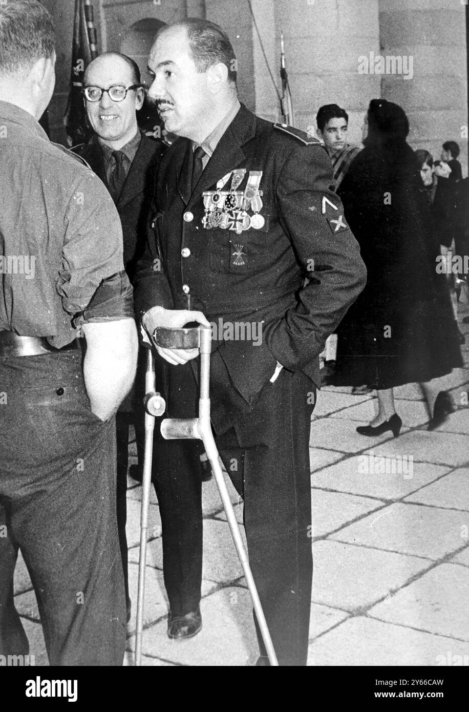Assister aux funérailles du fondateur du Parti Falange en Espagne Jose Antonio Primo de Rivera Un vétéran à une jambe de la Division bleue espagnole composée de militants Falange porte la Croix de fer le 25 novembre 1957 Banque D'Images