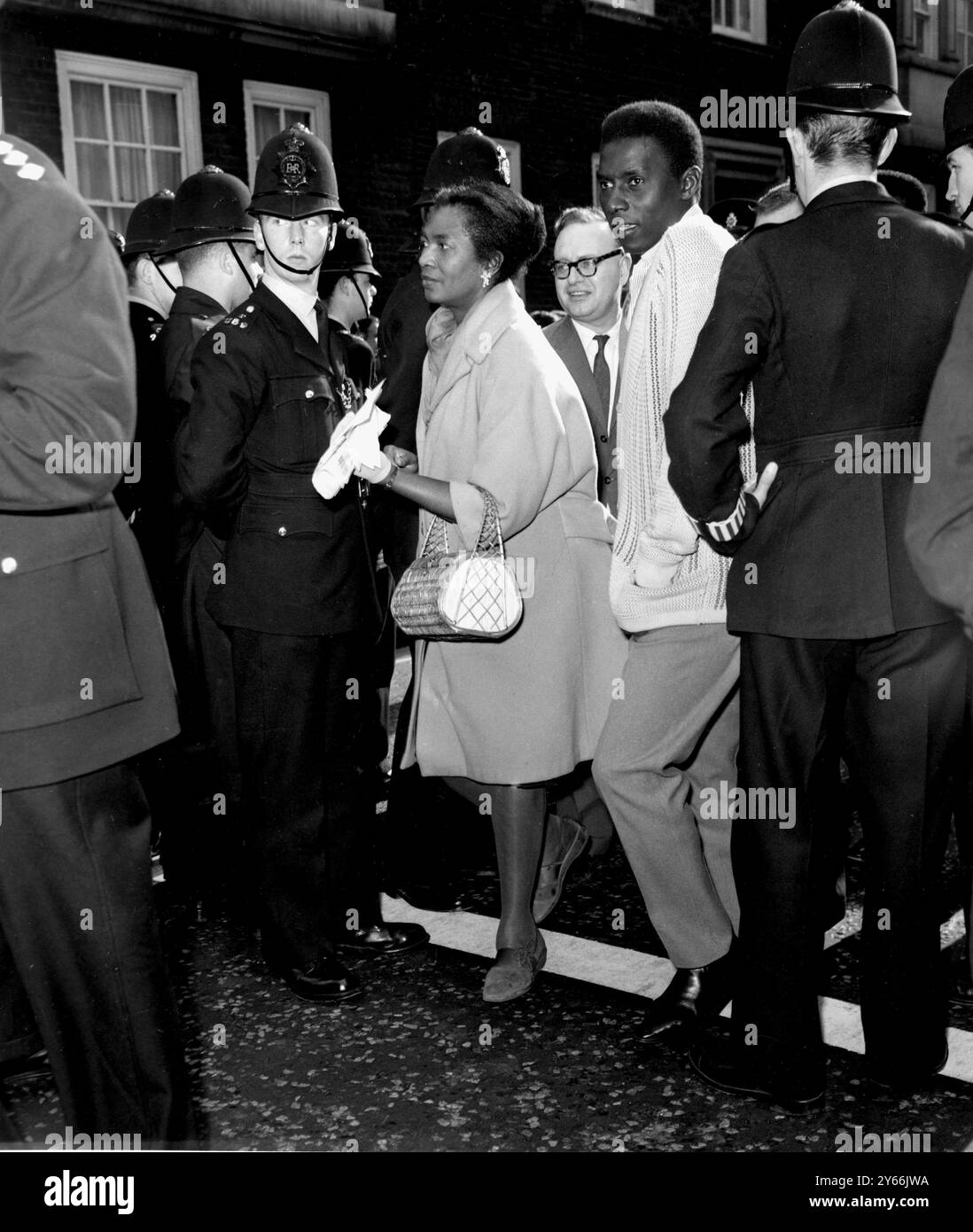 Mlle Claudia Jones (au centre) rédactrice en chef de la West Indian Gazette et présidente de l'Organisation afro-asiatique et caribéenne est autorisée par la police à se rendre à l'ambassade des États-Unis à Grosvenmor Square pour déposer une pétition appelant à la fin de la discrimination raciale. Londres - 31 août 1963. Banque D'Images