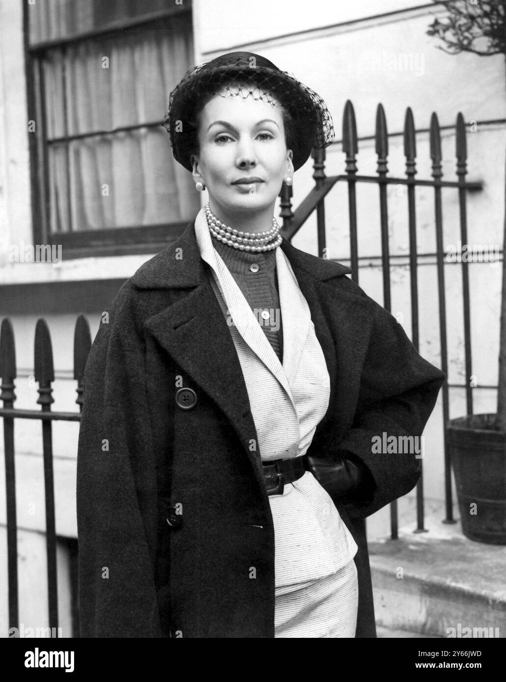Barbara Goalen, l'un des plus grands mannequins britanniques et une célèbre exposante du « look aux yeux de biche », a été photographiée chez elle à Chelsea avant de partir pour une exposition d'un mois de la mode britannique en Amérique, en Australie et en Nouvelle-Zélande. Elle part aujourd'hui (samedi), et est photographiée ici dans son enchevêtrement de vol : un costume deux pièces noir et blanc de tweed de soie avec un manteau pur cachemire. 19 janvier 1952. Banque D'Images