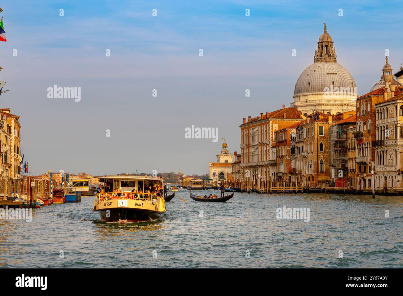 Un Vaporetto fait son chemin le long du Grand canal avec la basilique Santa Maria della Salute en arrière-plan, Venise, Italie Banque D'Images