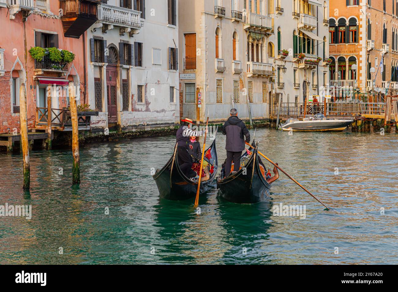 Deux gondoliers, côte à côte dirigent leur gondole le long du Grand canal à Venise, Italie Banque D'Images