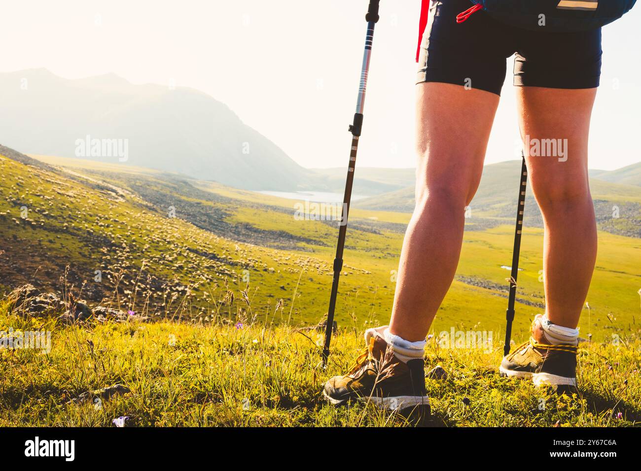 Vue rapprochée latérale femme randonneur debout jambes musclées à l'extérieur dans les montagnes. Concentrez-vous sur la botte Banque D'Images