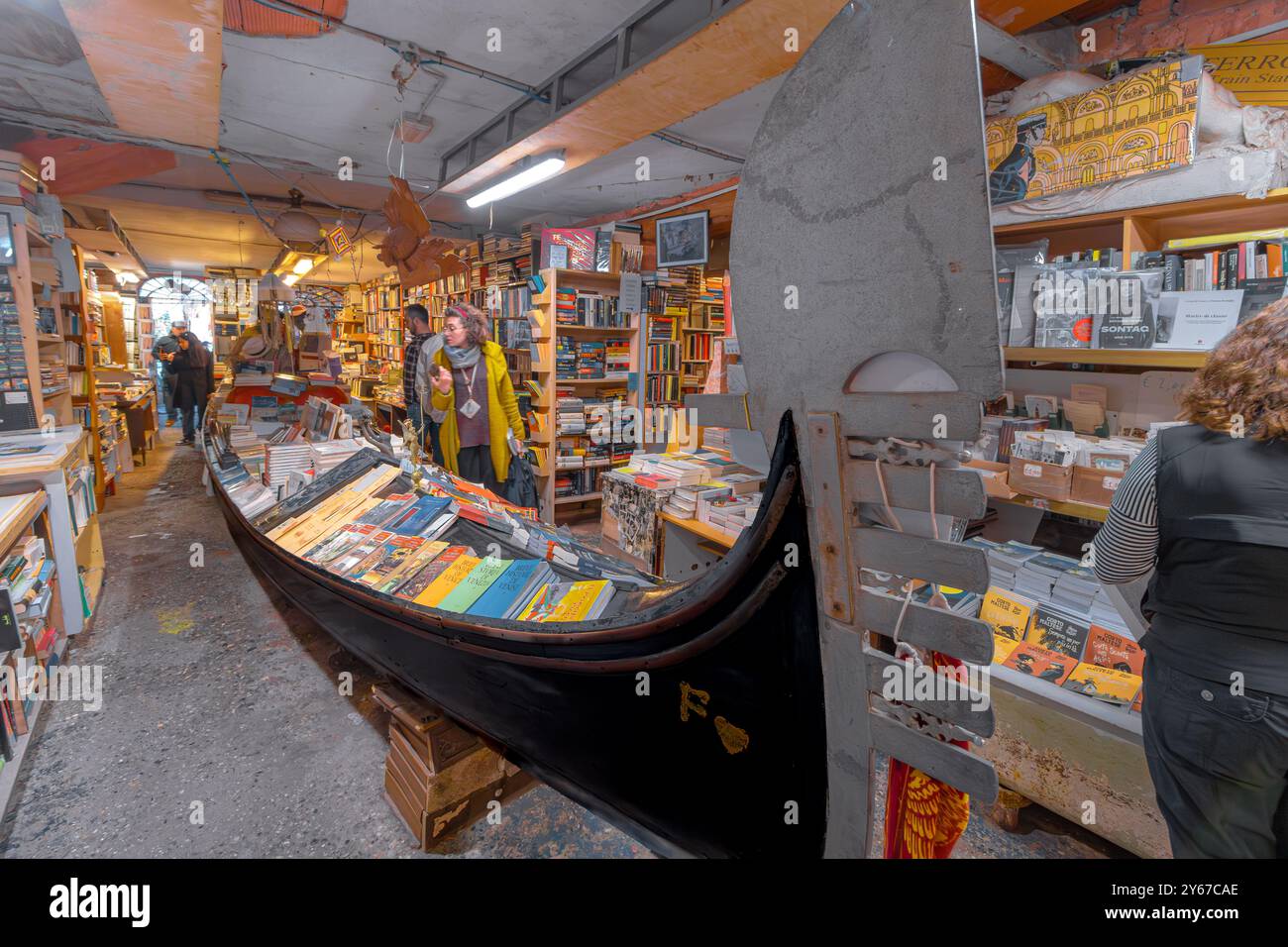 Les gens qui parcourent des livres à l'intérieur de Libreria Acqua Alta un magasin de livres original et populaire dans le sestiere Castello de Venise Italie Banque D'Images