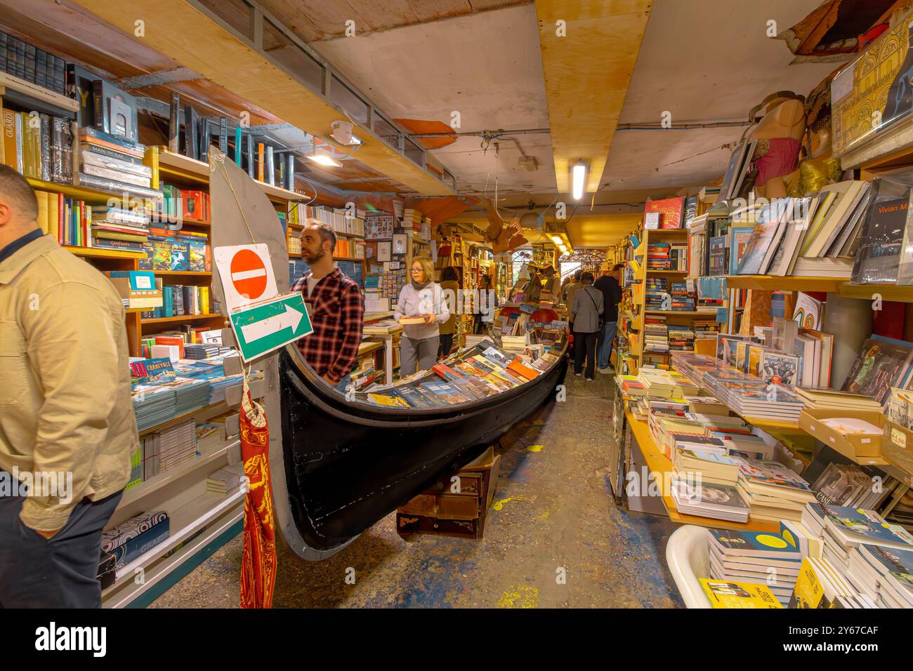 Les gens qui parcourent des livres à l'intérieur de Libreria Acqua Alta un magasin de livres original et populaire dans le sestiere Castello de Venise Italie Banque D'Images