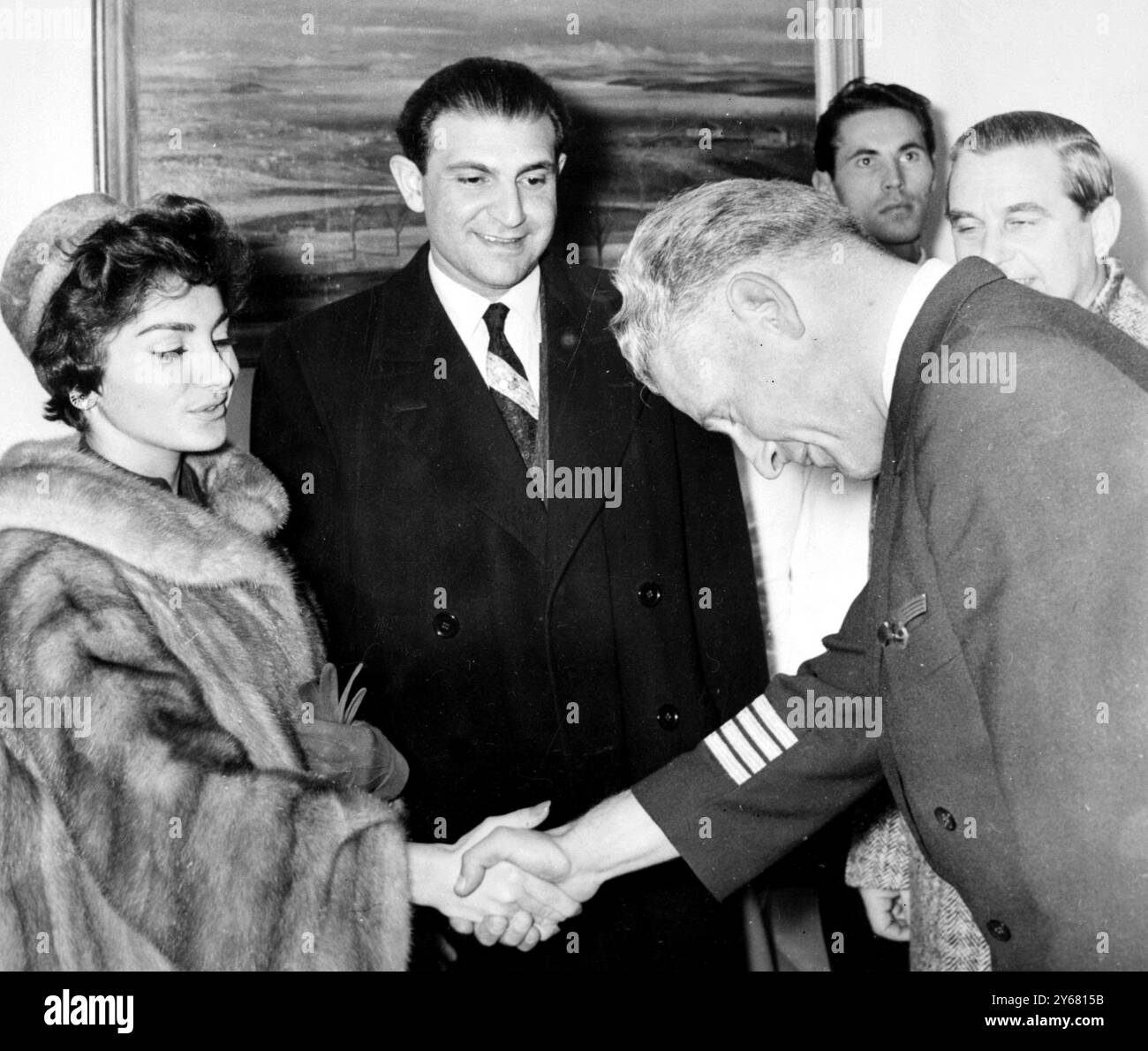 Munich : la princesse Shanaz, fille de 17 ans du Shan de Perse, serre la main du capitaine Stehle de la Lufthansa, après son arrivée à l'aéroport de Munich en provenance de Téhéran. En regardant au centre se trouve son mari, Ardeshir Sahedi. Le couple récemment marié passera sa lune de miel en Allemagne, en Suisse et en Italie. 19 novembre 1957 Banque D'Images