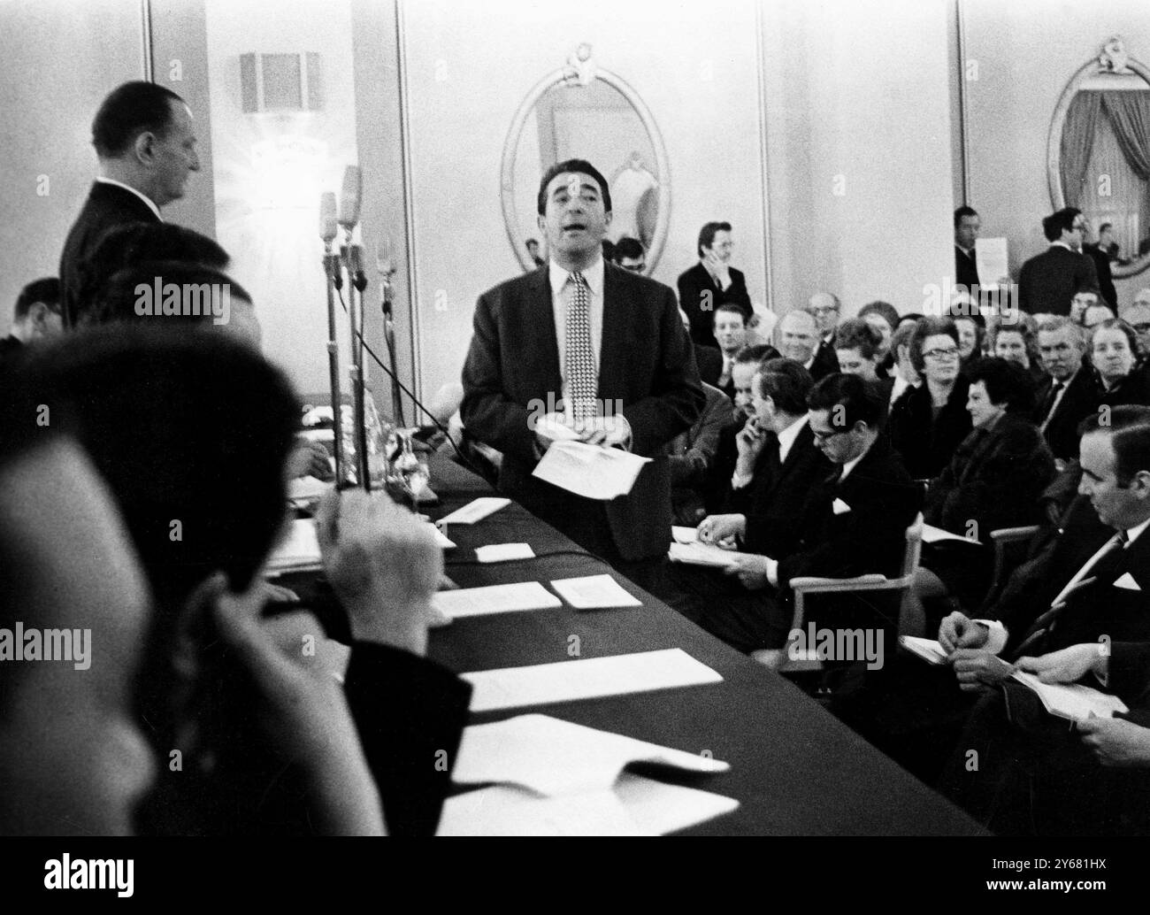 L'éditeur millionnaire Robert Maxwell (debout avec cravate de chèque) s'entretient avec Sir William Carr (debout à gauche) lors de la réunion extraordinaire d'aujourd'hui à Londres des actionnaires de News of the World Organisation au cours de laquelle un vote a été pris sur la question de savoir si la société devrait être reprise par Maxwell's Pergamon Press, ou en lien avec News Ltd, d'Australie. Au premier plan se trouve M. Rupert Murdoch (deuxième homme à partir de la droite), Chef de News Ltd. Le vote à main levée a été de 299 contre 20 en faveur d'une résolution en vertu de laquelle l'organisation NOW acquerrait certains intérêts australiens de News Ltd en échange de Banque D'Images