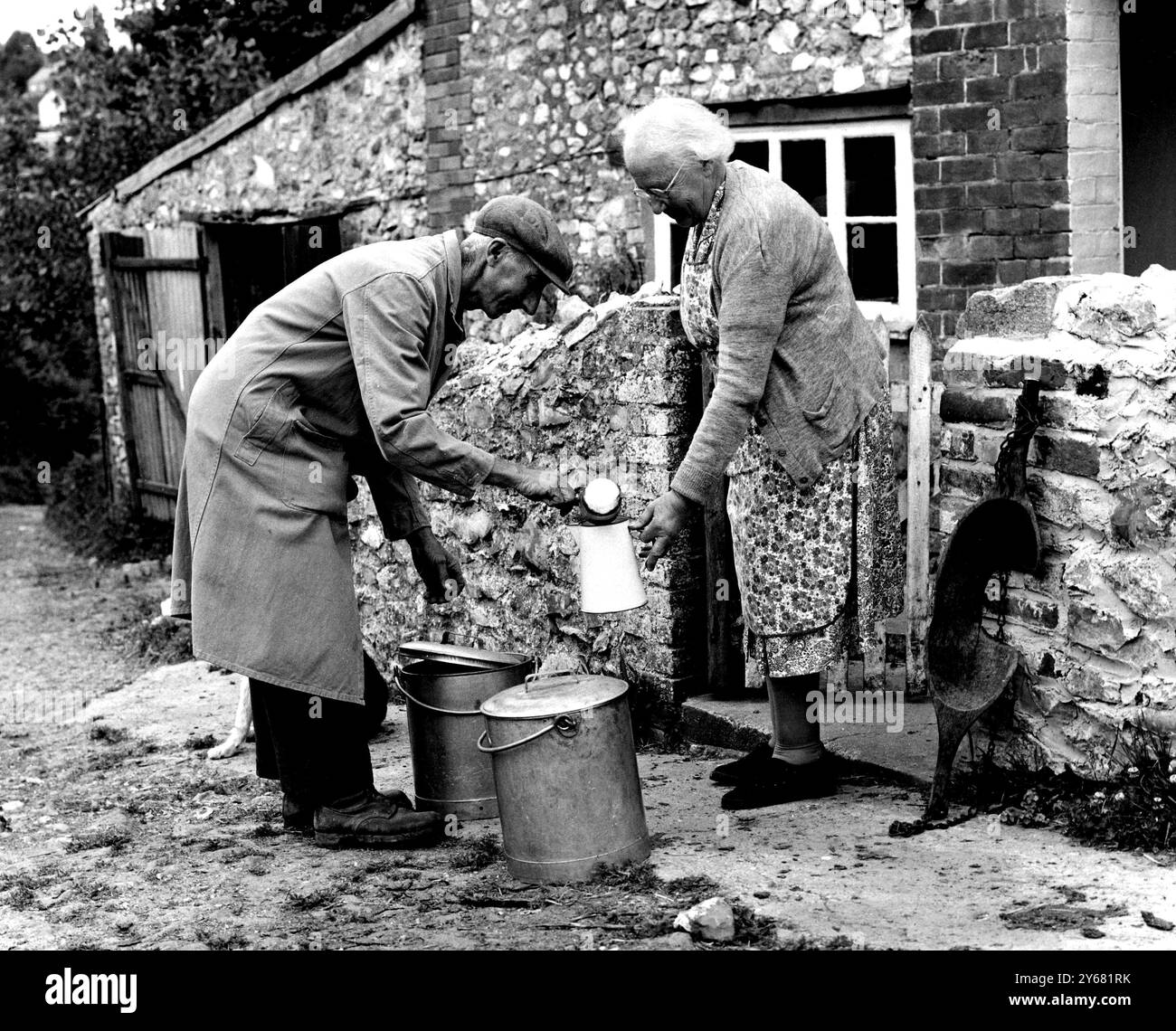 Sa dernière livraison par joug et seau est M. Reginald W Warren - dans le village de Thorncombe, Dorset. M. Warren vit à Sunnyside Farm, au bout du village où il cultive depuis 28 ans - il a 58 ans. Tenant un troupeau de 14 trayeurs dans l'Ayrshire et titulaire d'une licence de vente au détail de lait, il livre du lait dans la localité depuis quelques années - avec son joug et ses seaux - marchant de nombreux kilomètres au cours de son travail. Mais Thorncombe est l'une des dernières régions où il n'a pas été obligatoire de vendre le lait en bouteilles bouchées - mais maintenant que tout le pays arrive und Banque D'Images