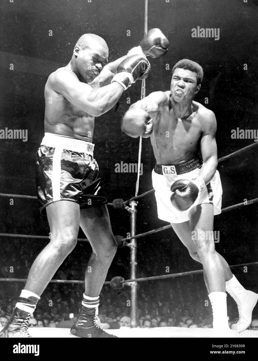 Doug Jones (à gauche) lève les mains alors que Cassius Clay laisse voler avec un rond-point à droite lors de leur combat de 10 tours poids lourds Contenders à Madison Square Garden, New York. Clay, qui avait prédit une victoire rapide à élimination directe, a dû se contenter d'une décision unanime sur Jones sur les points. 13 mars 1963. Banque D'Images