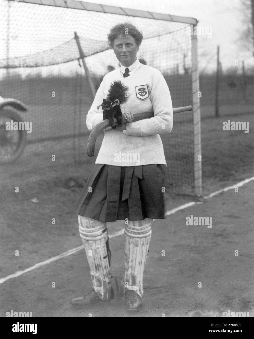 Ladies Hockey à Kew - East vs South 1922 Mme Higgins - la gardienne du Sud avec sa mascotte de chat noir. Banque D'Images