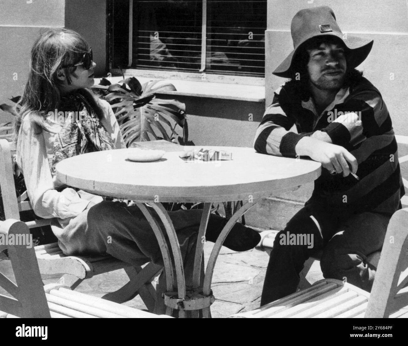 Rio de Janeiro, Brésil : Rolling Stones Mick Jagger et sa petite amie actrice-chanteuse Marianne Faithfull en vacances ici le 11 janvier. Les vêtements non rasés de Mick's Way-Out comprenaient un chapeau souple à large bord, avec une broche dorée, et une chemise à boucle orange et noire et un pantalon rose. 16 janvier 1968. Banque D'Images