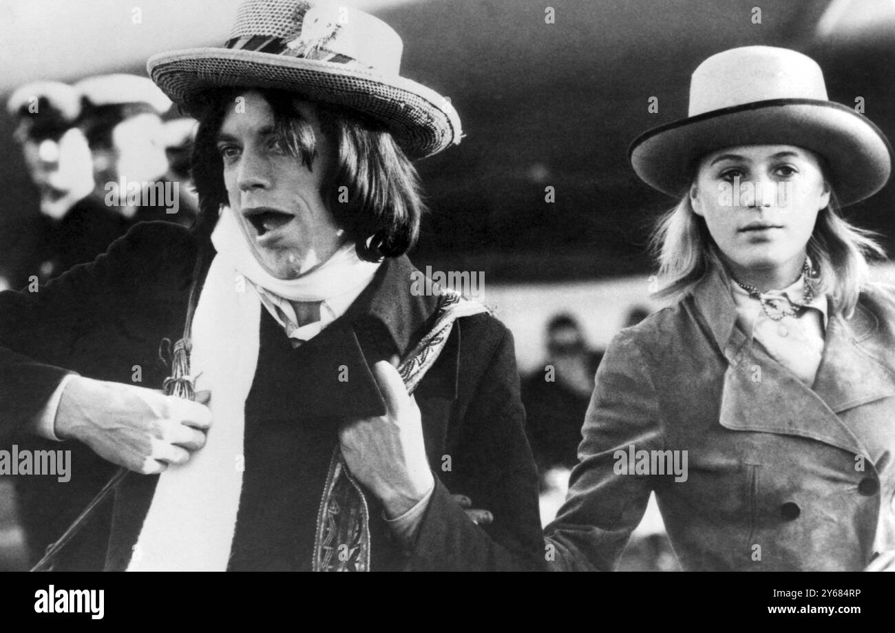 Sydney, Australie : Airport Antics par le leader et chanteur des Rolling Stones Mick Jagger. Il clown pour les photographes après être descendu d'un avion, accompagné de son amie l'actrice Marianne Faithfull. Ils sont arrivés pour prendre part à un film sur le célèbre bushranger australien Ned Kelly. Jagger jouera Kelly et Miss Marianne Faithfull sa sœur. Peu après leur arrivée, l'actrice s'est effondrée et a été emmenée à l'hôpital le 11 juillet 1969 Banque D'Images