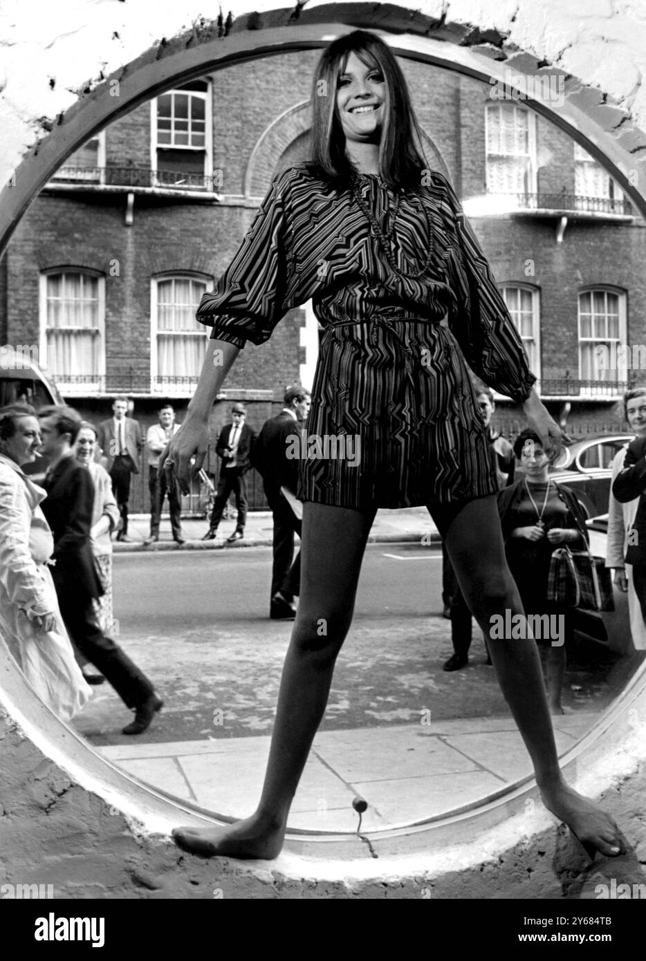 Londres : il n'y a pas de cordes attachées à cette marionnette ... chanteuse pop britannique Sandie Shaw... ajuste les mouvements selon les instructions des photographes. Au milieu des regards curieux des gens dehors... Sandie utilise une fenêtre comme cadre... Alors qu'elle montre pour la première fois sa première gamme de vêtements, avec le label Sandie Shaw... une des plus grandes entreprises de prêt-à-porter du pays soutient la chanteuse pop dans sa nouvelle aventure de rejoindre le commerce du chiffon... 26 septembre 1967 Banque D'Images