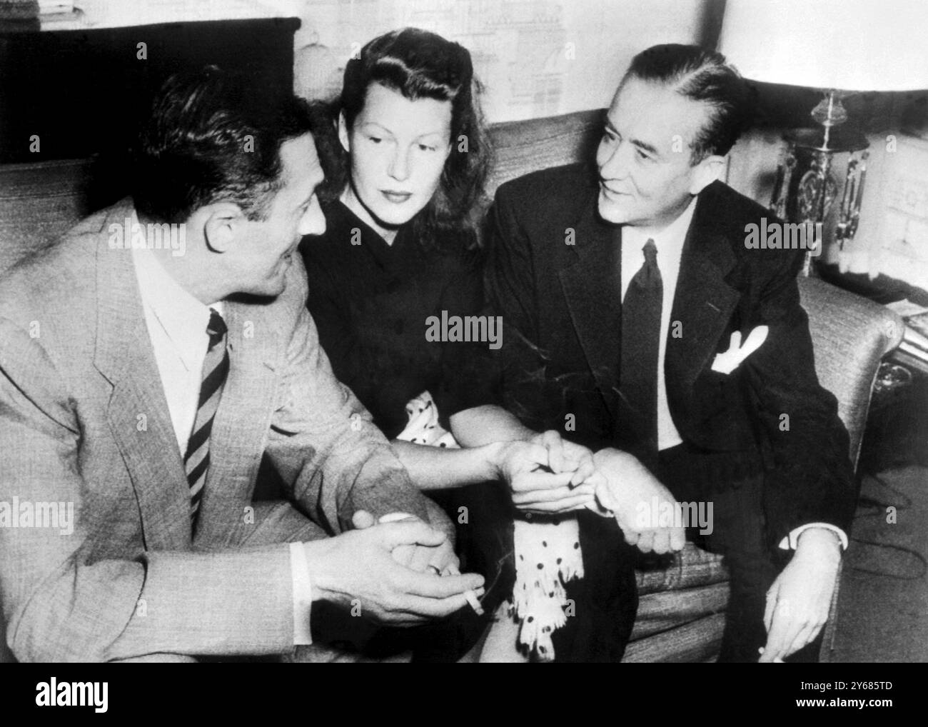 Beverly Hills, Californie : l'actrice Rita Hayworth en conférence avec son avocat, Bartley Crum (à droite) et le représentant légal du prince Aly Khan Charles Toren (à gauche). Rita, en visite à Beverly Hills depuis sa résidence de divorce au Nevada, a rencontré les avocats dans son bungalow d'hôtel. 12 juillet 1951 Banque D'Images