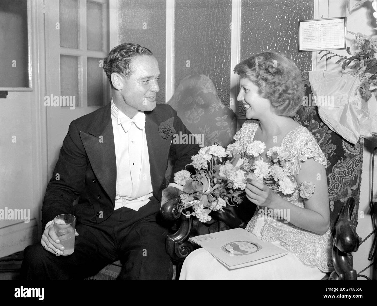 Rita Hayworth, l'actrice de cinéma, a assisté à la première mondiale de son film 'Down to Earth' au Gaumont Theatre, Haymarket, Londres hier soir. Le produit de la performance est destiné à aider la British Limbless ex-Servicemen's Association. Rita entra par l'entrée arrière du Théâtre pour s'affranchir de la foule des fans de cinéma qui attendaient de la voir, puis se rendit au foyer où elle fut présentée à la duchesse de Gloucester. I.N.P photo montre Rita Hayworth dans un duo souriant avec le Group-Captain Douglas Bader, as de l'air sans legless, à la première. 22 juin 1947 Banque D'Images