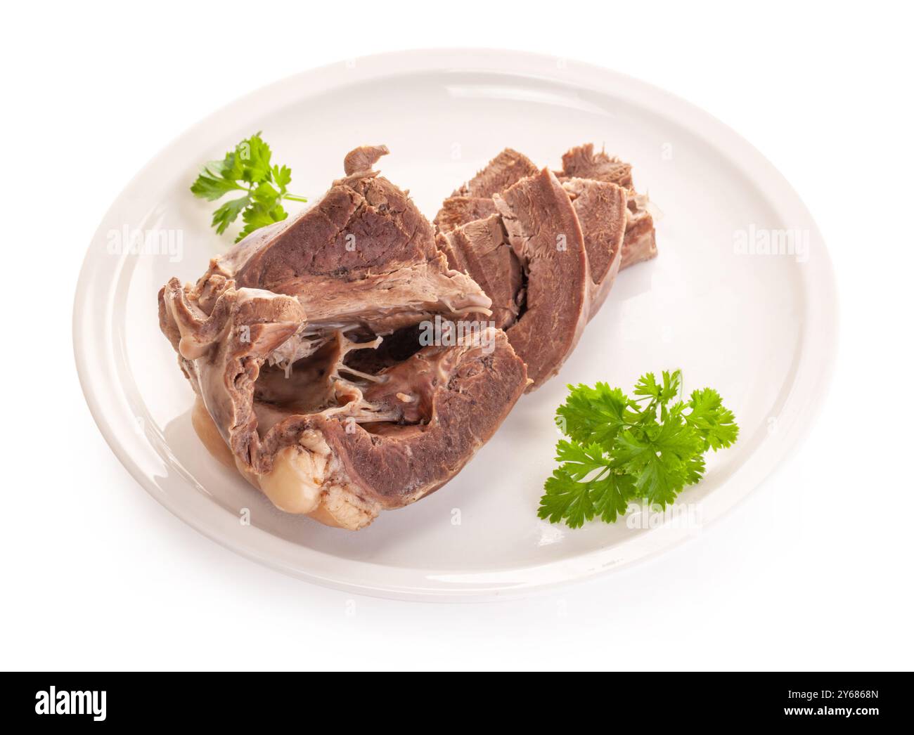 coeur de boeuf bouilli dans une assiette blanche avec persil. le sous-produit alimentaire diététique a une faible teneur en calories. isolé sur fond blanc Banque D'Images