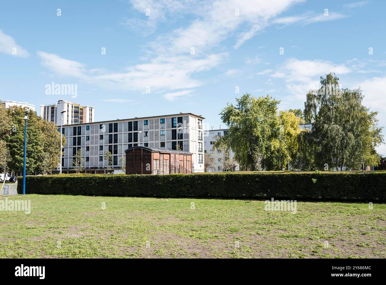 Le wagon commémoratif de la SNCF, installé en 1980, avec des bâtiments en arrière-plan. Le Mémorial de la Shoah à Drancy a été inauguré le 21 septembre 2012 par le président français François Hollande. Le mémorial se trouve en face de la Cité de la Muette et est une branche du Mémorial de la Shoah à Paris. France, Paris, 12 septembre 2024. La Muette s The cite, conçu dans les années 1930 pour fournir des logements à bas prix aux familles de Drancy, le complexe de bâtiments inachevés a servi de camp d'internement et plus tard de camp de concentration pour les Juifs. Près de 63 000 ont été déportés de Drancy vers les camps d'extermination. Banque D'Images