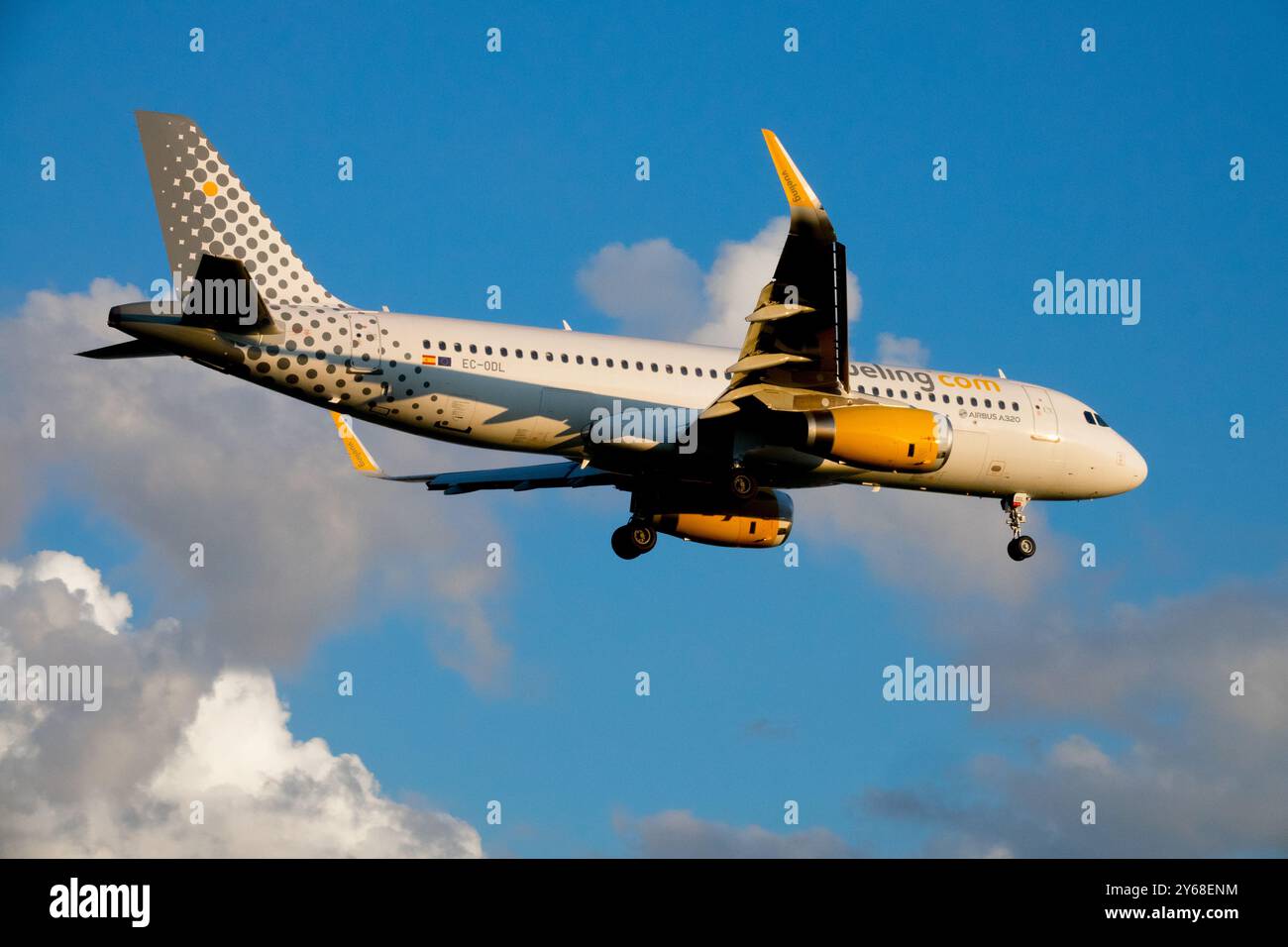 Avion Vueling avion de compagnie aérienne low-cost atterrissant sur le ciel bleu avec des nuages Banque D'Images