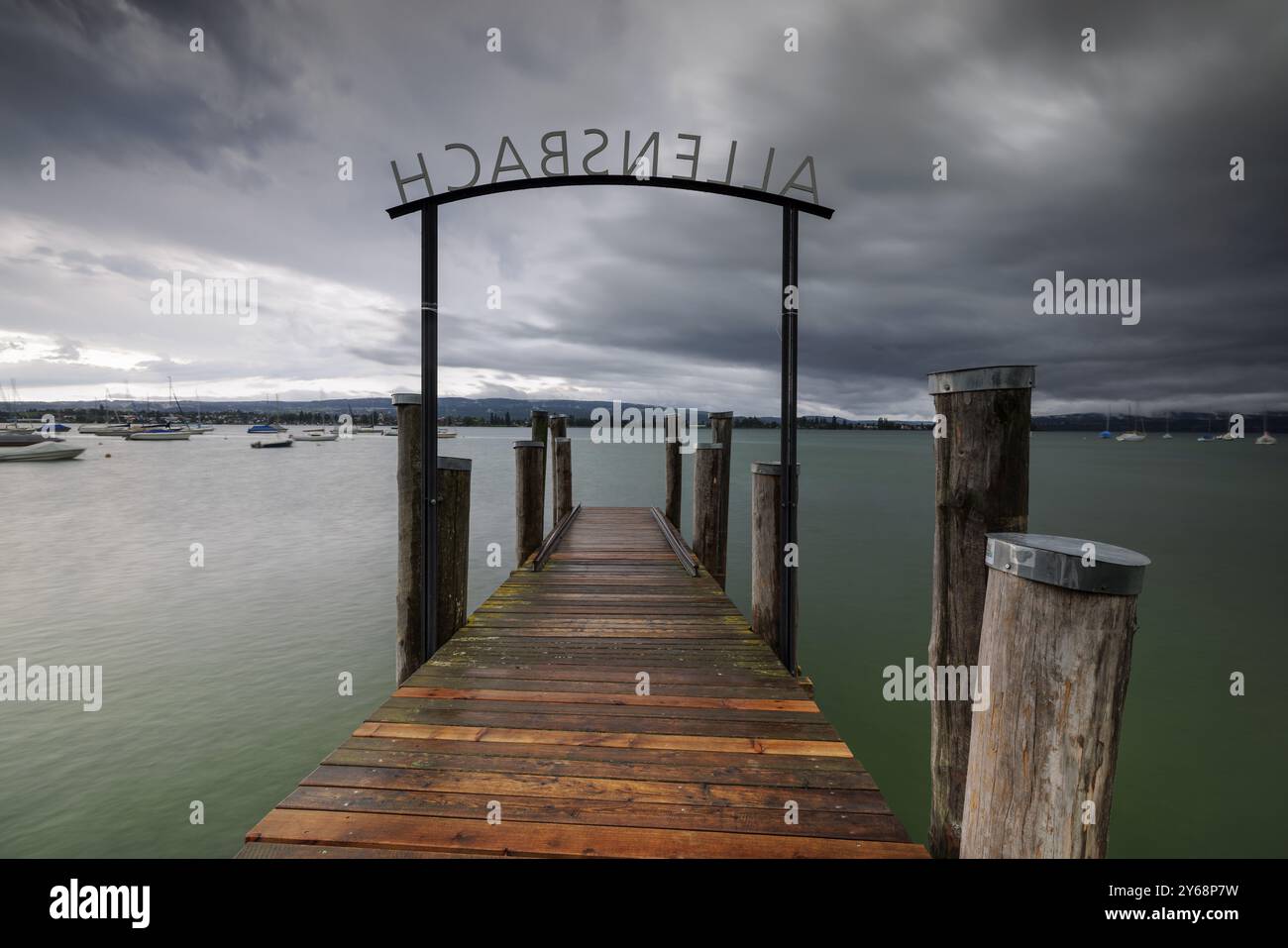 Passerelle en bois mène à un lac sous un ciel orageux, Allensbach, Untersee, lac de Constance, Constance District, Bade-Wuertemberg, Allemagne, Europe Banque D'Images