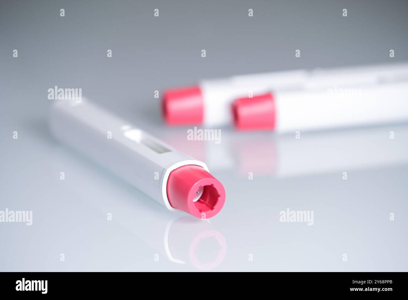 Composition avec trois stylos injecteurs à pointe rouge pour les traitements biologiques tels que l'adalimumab, l'étanercept ou l'épinéphrine. Le fond est aseptique Banque D'Images