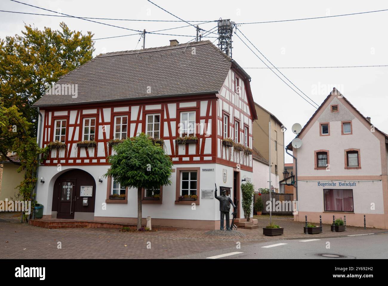 DAS Rathaus der rheinhessischen Gemeinde Uelversheim wurde 1797 erbaut und 1984/85 umfassend restauriert. Es handelt sich BEI dem Bau um einen freistehenden Krüppelwalmdachbau mit zwei Stockwerken. In der Südwand des massiv verputzten Erdgeschosses ist der Werkstein eingebaut, dessen Inschrift ULVERSHEIM / 1797 das Jahr der Erbauung des Gebäudes belegt. Gut zu sehen ist auch noch die überirdische Stromversorgung an einem Gittermât 24.09.24 *** L'hôtel de ville de la municipalité rhéno-hesse d'Uelversheim a été construit en 1797 et largement restauré en 1984. Il s'agit d'un autoportant à hanches infirmes Banque D'Images