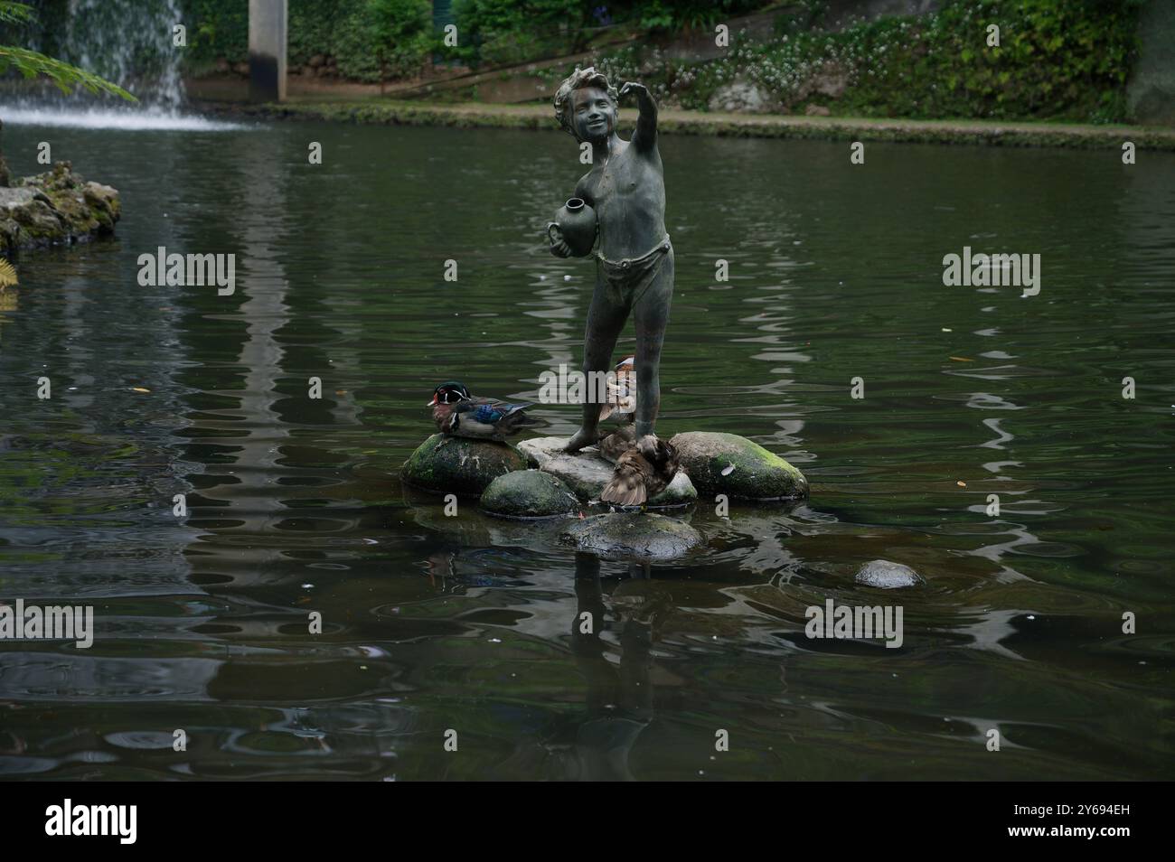 Statue d'enfant ludique avec des canards sur un étang, jardins du palais monte Banque D'Images