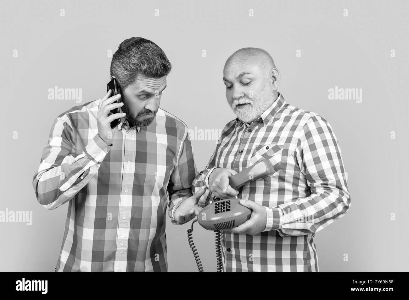 hommes étonnés avec appel de contraste téléphonique isolé sur jaune. hommes avec appel de contraste téléphonique Banque D'Images