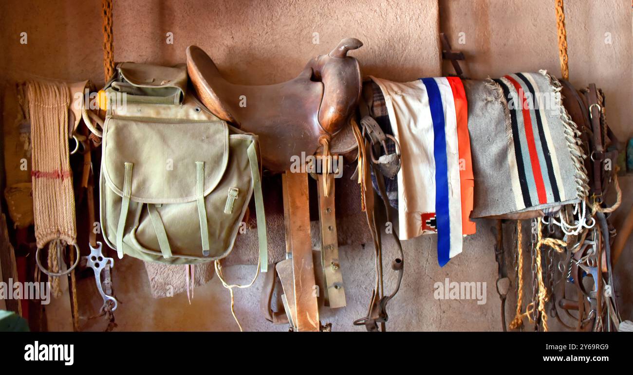 Selle, couvertures colorées, sac de selle et tack d'équitation pend de corde au plafond. Banque D'Images