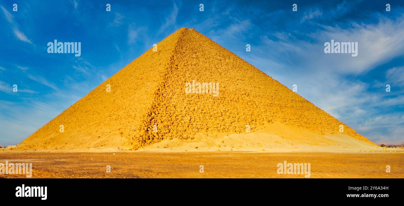 Magnifique vue grand angle de la pyramide rouge construite par Pharoah Snefuru, ainsi appelée en raison de la teinte rougeâtre des blocs de calcaire brillants dorés dans le soleil du désert à Dahshur au Caire, en Égypte Banque D'Images