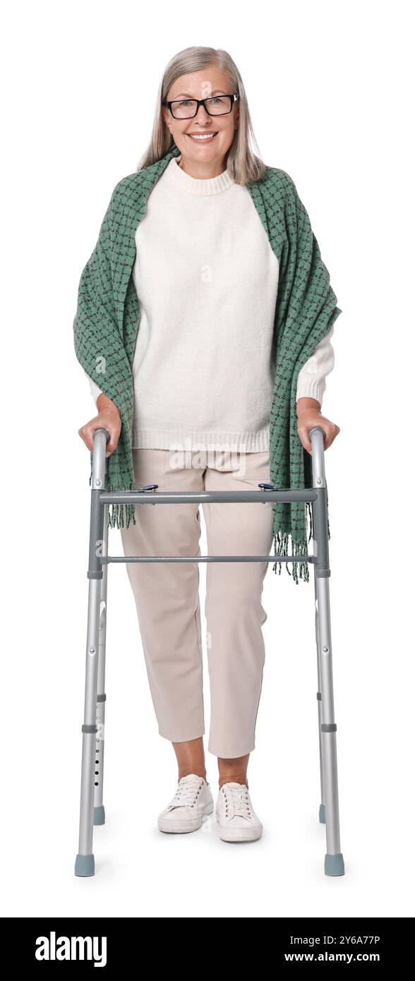 Femme senior utilisant le cadre de marche sur fond blanc Banque D'Images